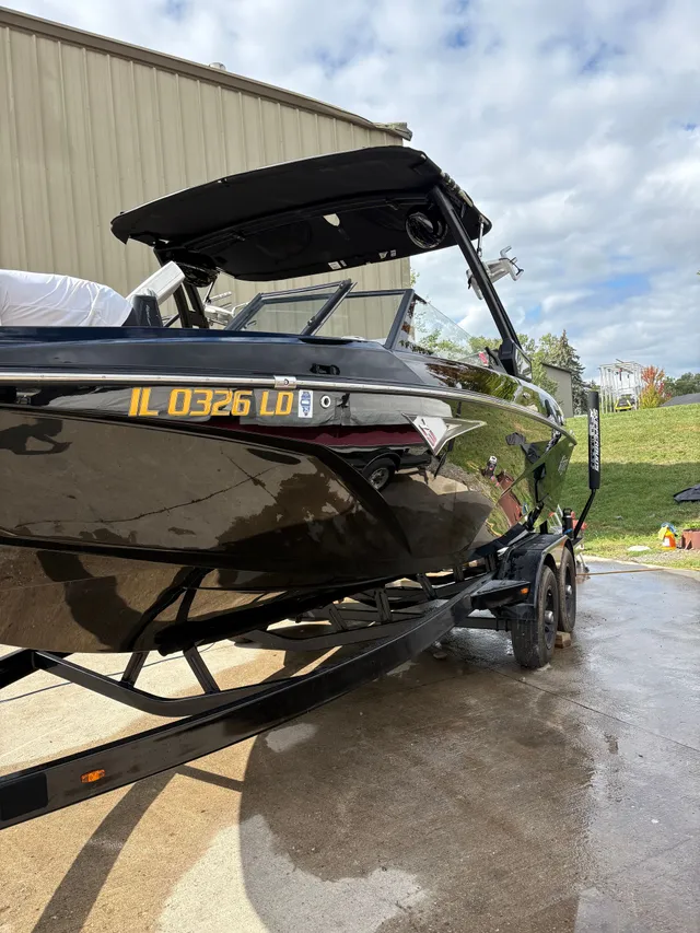 Freshly detailed black wakeboard boat on trailer