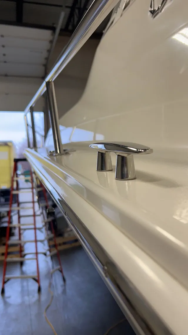 Close-up of polished chrome cleat on a clean white hull
